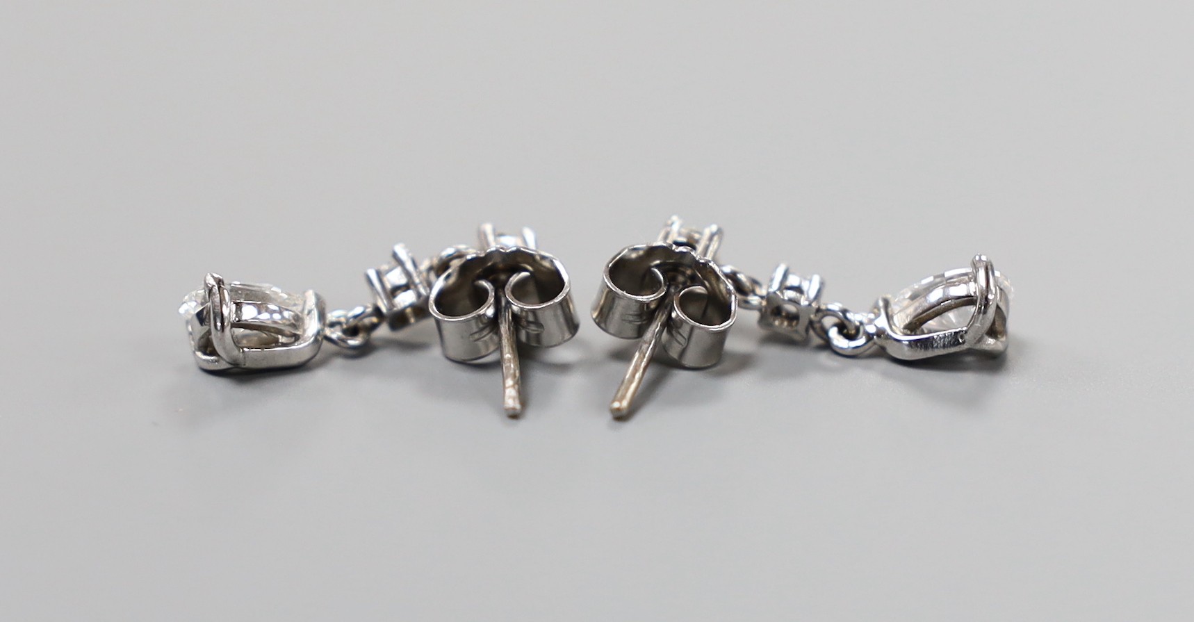 A modern pair of 750 white metal, pear and round cut diamond set drop earrings, 18mm, gross weight 2.8 grams